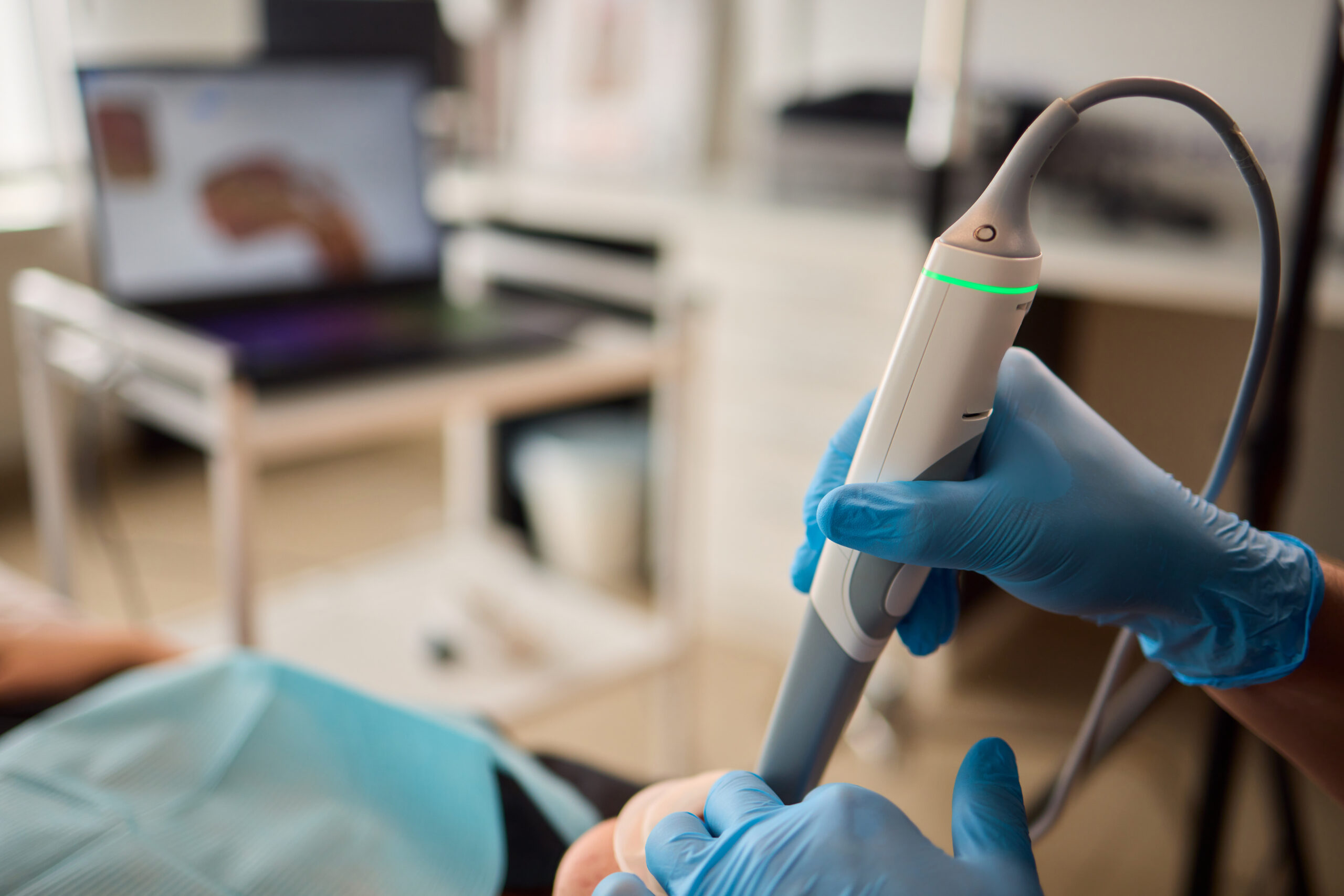 Healthcare professionals use advanced ultrasound technology for precise patient diagnostics and treatment Dentist scanning patient with dental intraoral scanner and controls process on laptop screen. Prosthodontics and stomatology concept