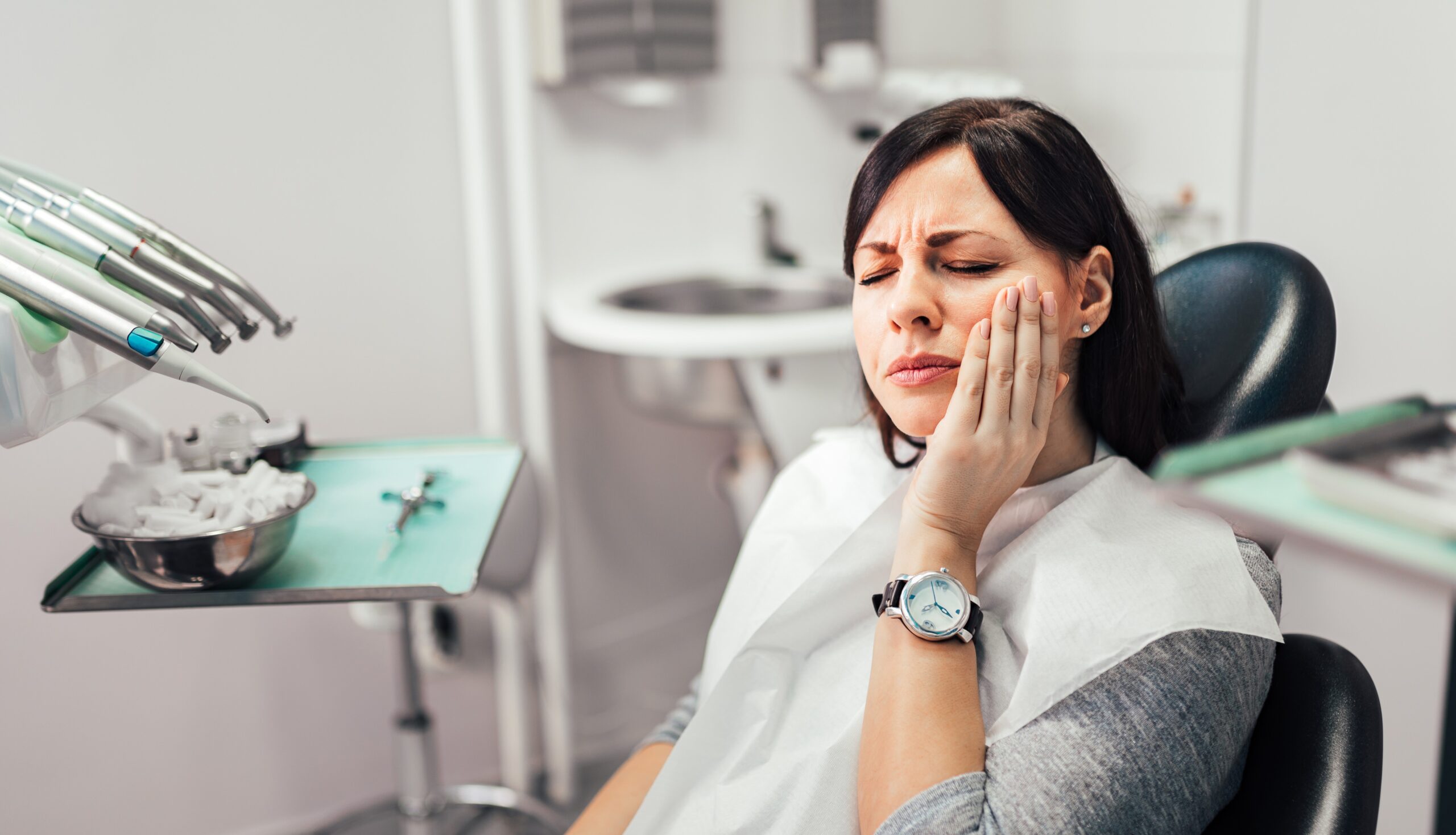 Woman with toothache at dentist office.