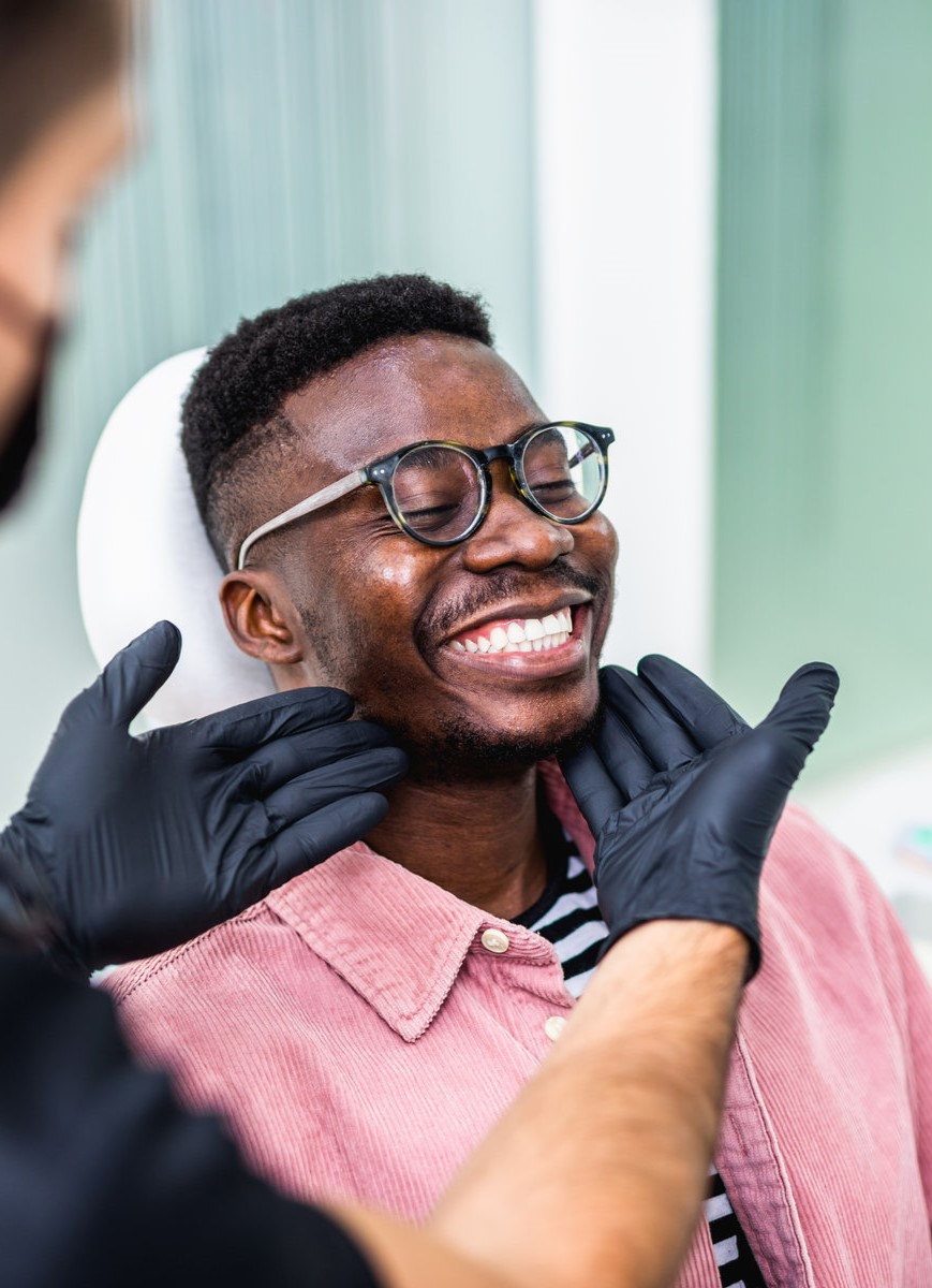 African American young man having a visit at the dentist's. He is sitting on chair at dentist office in dental clinic.