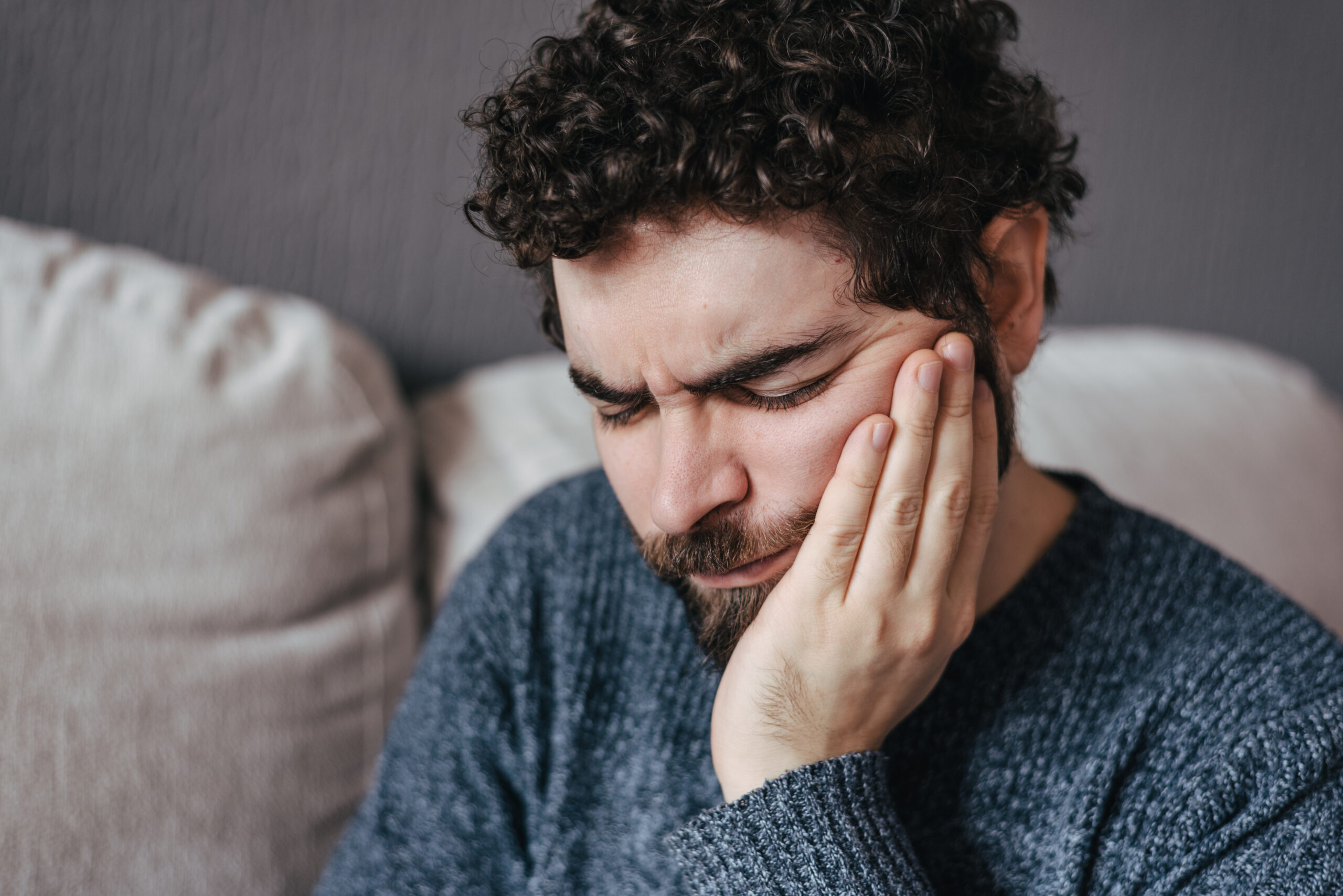 Man in pain suffering from toothache. Dental pain on teeth. Dentist